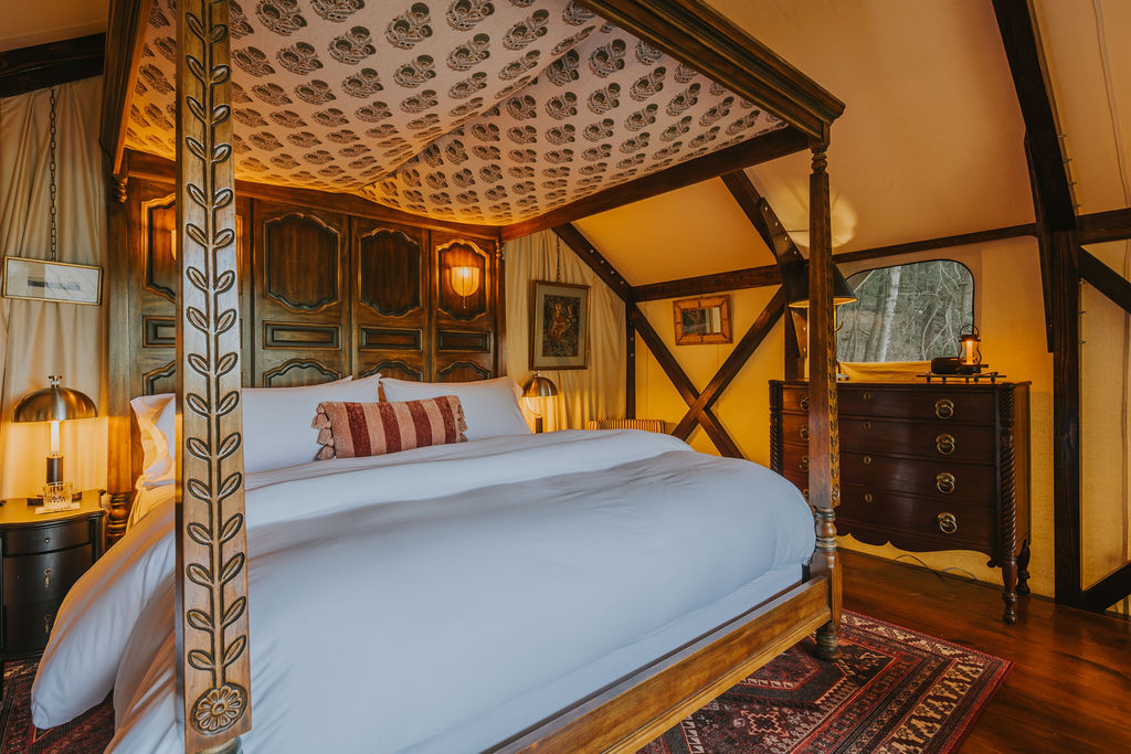 South Camp interior with four-poster bed and warm lantern light