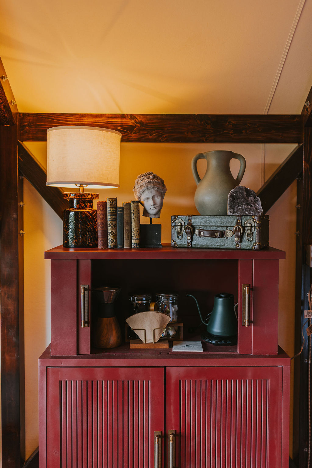 Red painted cabinet and lamp in the South Camp interior